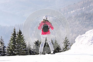 Woman skiing on snowy hill in mountains. Winter