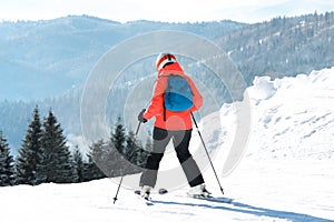 Woman skiing on snowy hill in mountains. Winter