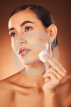 Woman, skincare beauty and cotton for face, health and cleaning for cosmetic glow by brown studio backdrop. Model