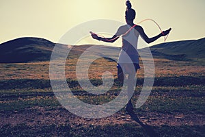 Woman skipping rope on grassland trail