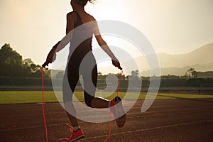 Woman skipping rope during sunny morning