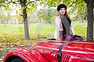 Woman in skirt on red car cowling