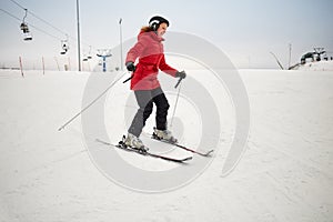 Woman skis on slope in winter day at sports photo