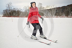 Woman skis on slope in winter day at sports photo