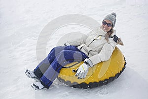 Woman sledding down a hill on a snow tube photo