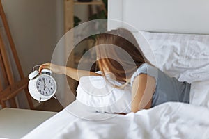 Woman sleep on the bed turns off the alarm clock wake up at the morning, Selective focus.