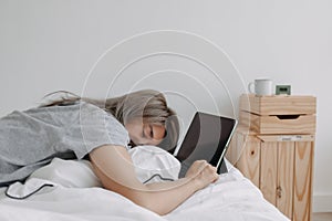 Woman sleep on tablet computer on bed in the morning. Early online work.