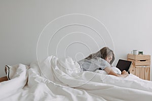 Woman sleep on tablet computer on bed in the morning. Early online work.