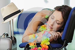 Woman sleeping at airport while waiting for flight