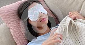 Woman sleeping with eye mask on sofa