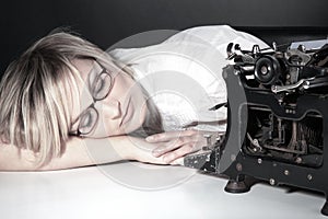 Woman sleeping with glasses and old typewriter