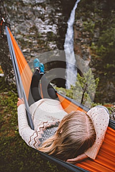 Woman sleeping in hammock with waterfall view in forest outdoor summer vacation girl traveling in Norway camping vibes