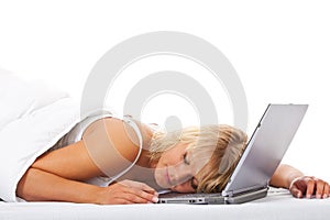 Woman sleeping on her laptop in bed