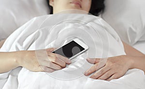 Woman sleeping and holding a mobile phone.
