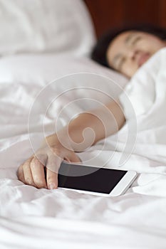 Woman sleeping and holding a mobile phone.