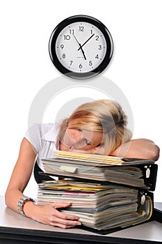 Woman sleeping over a pile of files