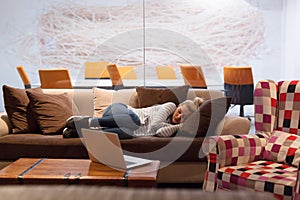 Woman sleeping on a sofa in a creative office