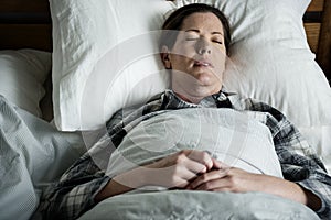 A woman sleeping soundly on bed photo