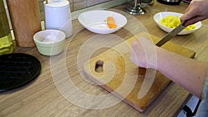 woman slice potatoes on cut board