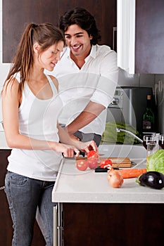 Woman slicing tomatoes with her boyfriend