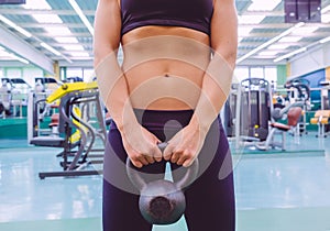 Woman with slim waist and black sportswear holding