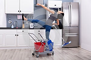 Woman Slipping While Mopping Floor In Kitchen