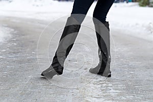 Woman slips on slippery road covered with ice. Concept of injury risk in winter. photo