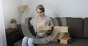 Woman small online business owner preparing package for shipping on laptop at home. sme entrepreneur