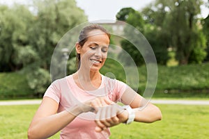 Woman with smart watch or fitness tracker in park