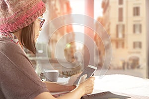 Woman and smarthphone in hand sitting in coffee ship against eur