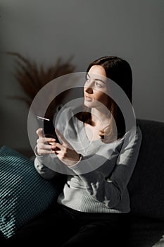 Woman with smartphone on couch