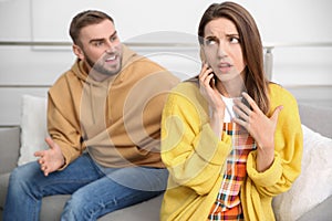 Woman with smartphone ignoring her boyfriend. Relationship problems