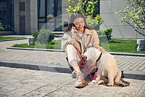 Woman with a smartphone looking at her pet