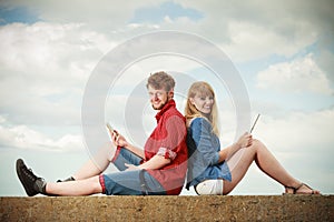 Woman with smartphone man with tablet couple outdoor