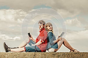 Woman with smartphone man with tablet couple outdoor