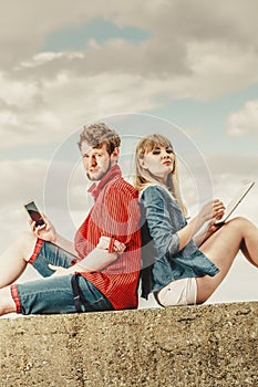 Woman with smartphone man with tablet couple outdoor