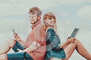 Woman with smartphone man with tablet couple outdoor