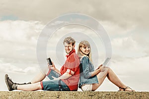 Woman with smartphone man with tablet couple outdoor