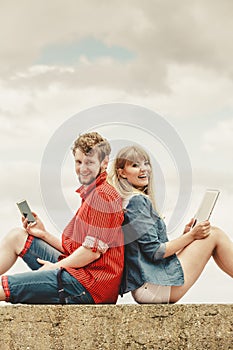 Woman with smartphone man with tablet couple outdoor