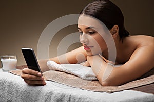 Woman with smartphone at spa or massage parlor