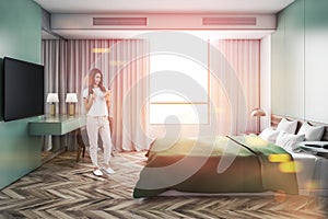 Woman with smartphone in stylish bedroom