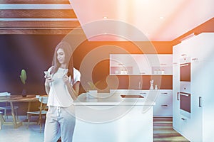 Woman with smartphone in stylish kitchen interior