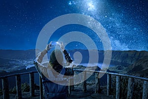 Woman with a smartphone under a starry night sky