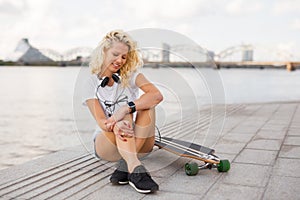 Woman with smartwatch on her wrist and longboard
