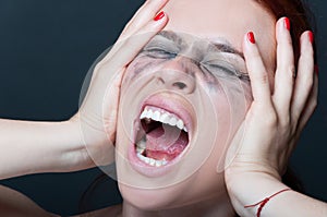 Woman with smeared mascara screaming