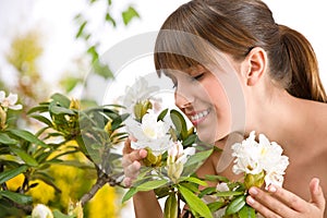 Woman smelling blossom of Rhododendron flower