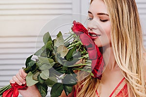 Woman smelling bouquet of red roses