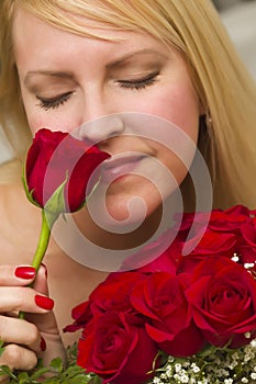 Woman Smelling a Bunch of Red Roses