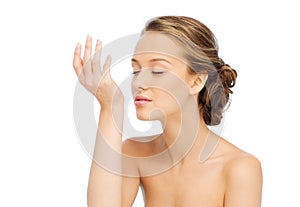 Woman smelling perfume from wrist of her hand