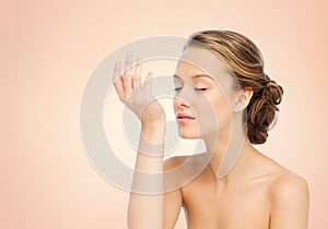 Woman smelling perfume from wrist of her hand